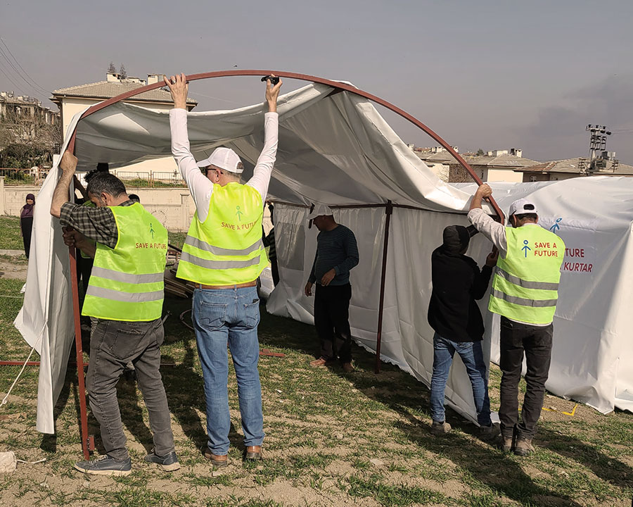 Men helping put up a tent for people displaced by an earthquake.